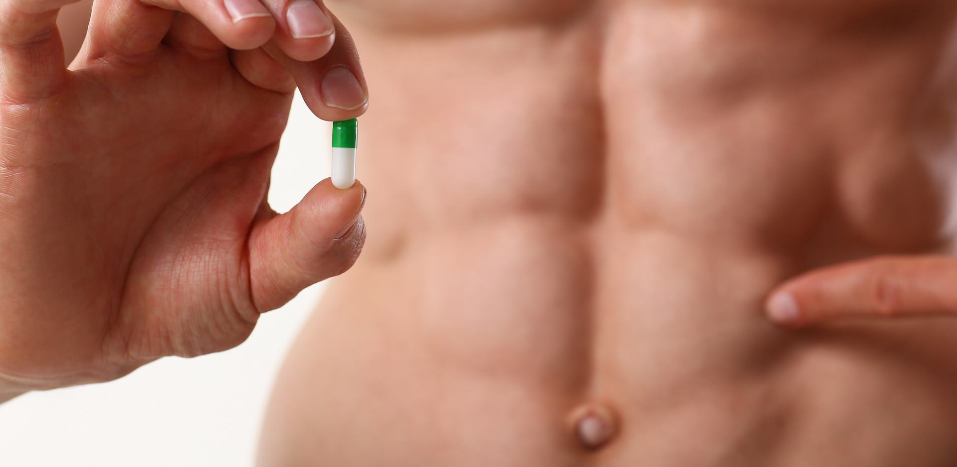 Pro Anabolic Steroid Test Close-up of a person holding a green and white capsule.