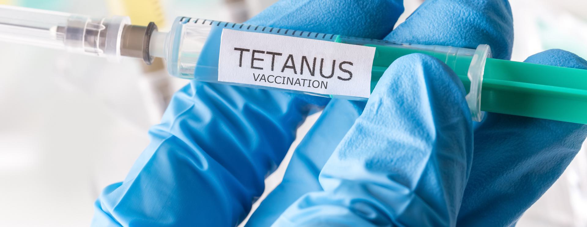 Tetanus Vaccine (TDAP) Close-up of a syringe labeled 'Tetanus Vaccination' held by a gloved hand.