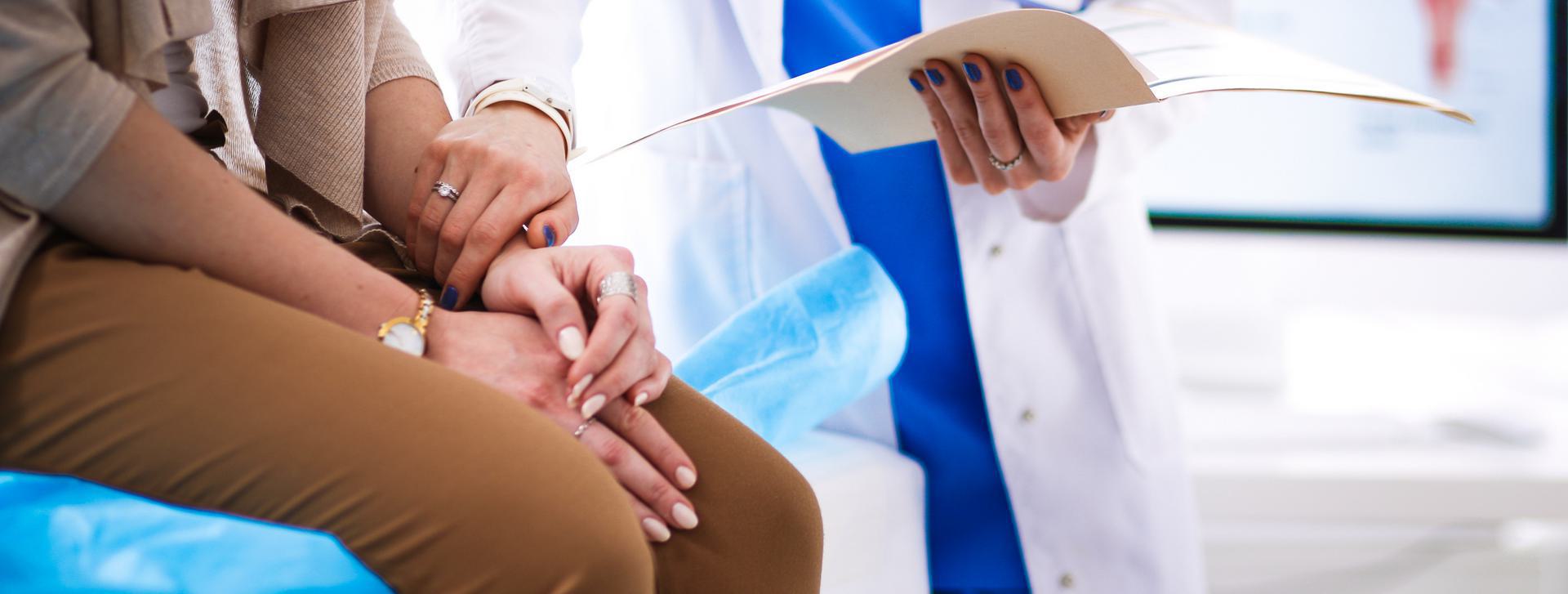 Emergency Date Rape Drug Test Doctor comforting a patient while holding medical documents.