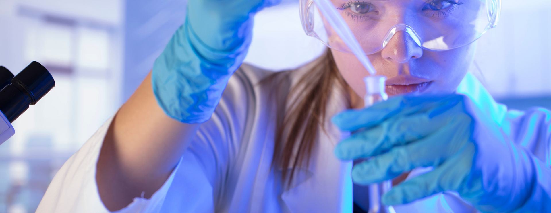 25 Panel Urine Drug Test Scientist wearing safety goggles and gloves using a pipette in a laboratory.