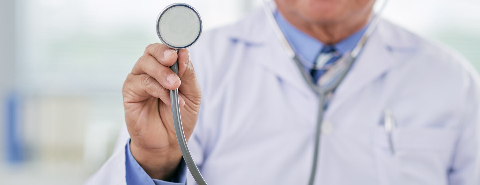 Non-DOT Employment Physical Doctor holding a stethoscope towards the camera, wearing a white coat.