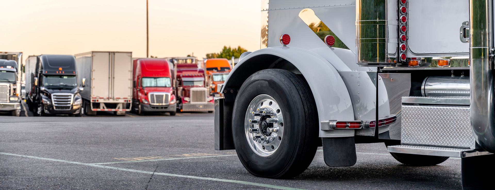 Delaware Contractor Random Pool Close-up of a parked semi-truck with other colorful trucks in the background at a truck stop.