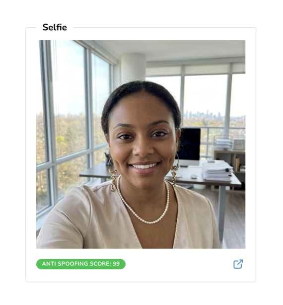 Person smiling in a bright office with large windows and city view.